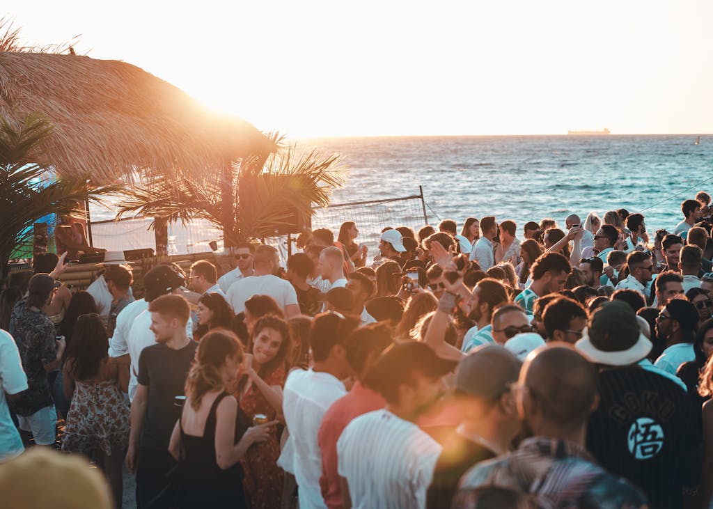 Crowd enjoying a vibrant beach party with stunning sunset views in Australia.